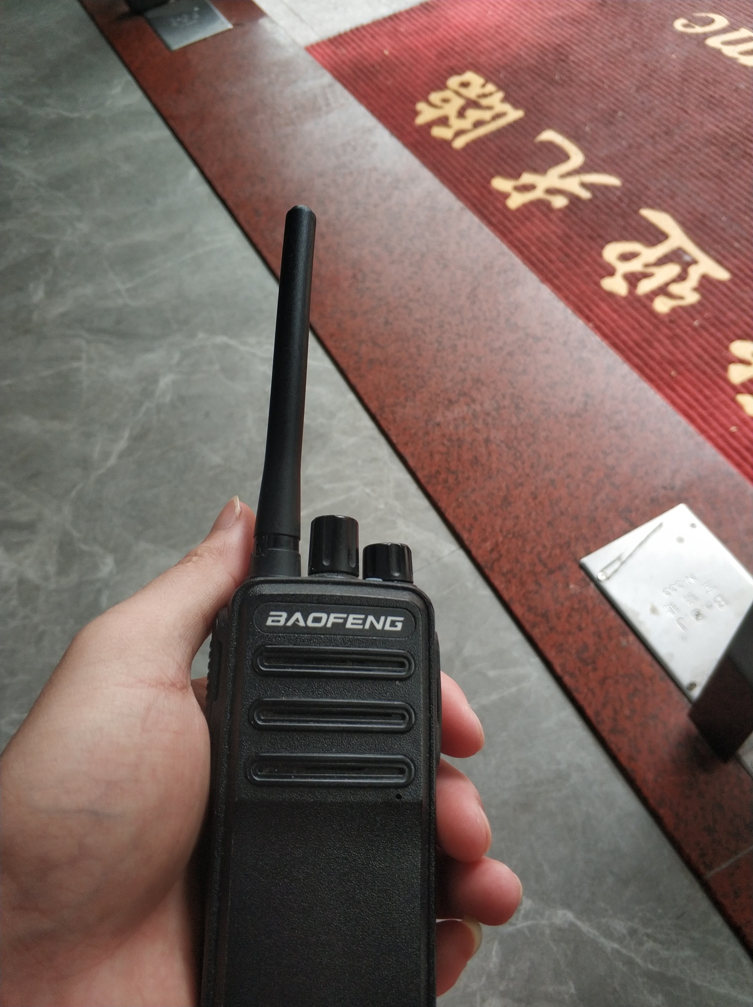 拿着对讲机坐在门口有客人2位一天就是这么下来了